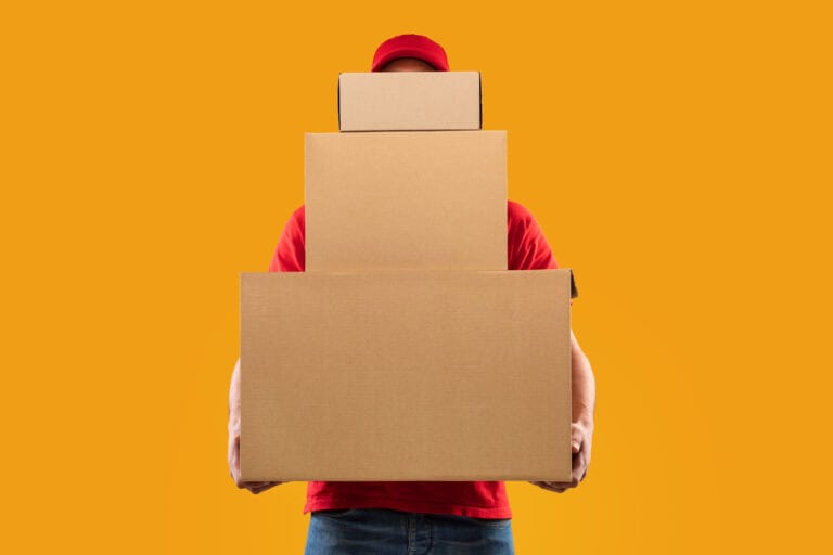 Unrecognizable Courier Holding Many Cardboard Boxes Delivering Packages, Yellow Background